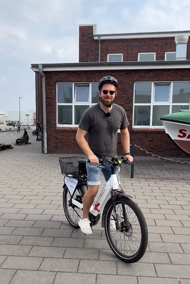 Ein Mann steht auf seinem Fahrrad und will losfahren