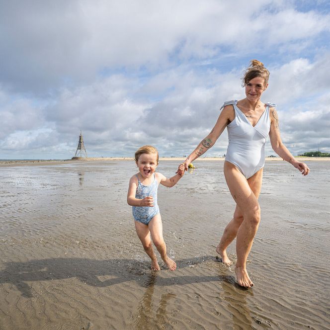 Eine Mutter läuft durchs Watt in Döse