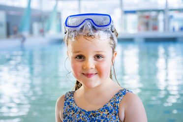 Ein Kind steht vor dem Becken und wartet auf den Schwimmkurs