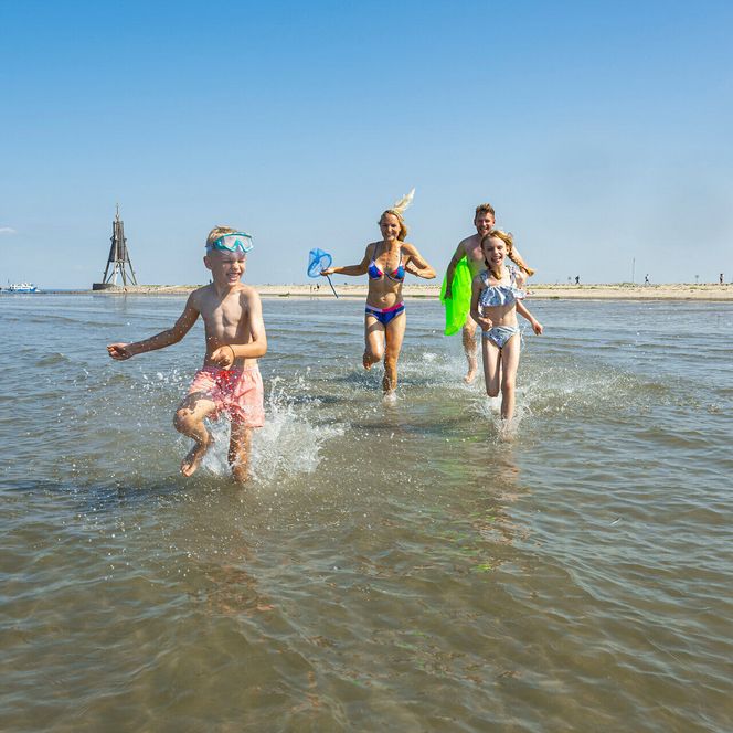 Eine Familie badet am Strand von Döse