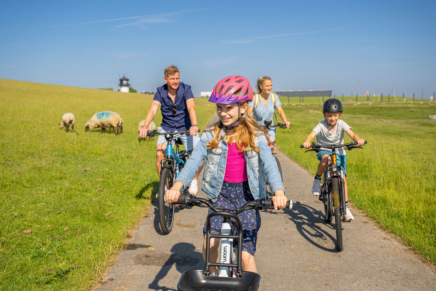 Eine Familie macht eine Radtour entlang des Deiches