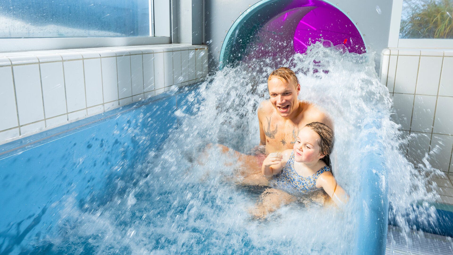 Papa mit Kind rutscht die Rutsche im ahoi!