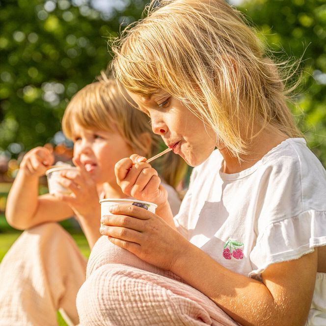 Kinder essen Eis auf der Wiese im Kurpark