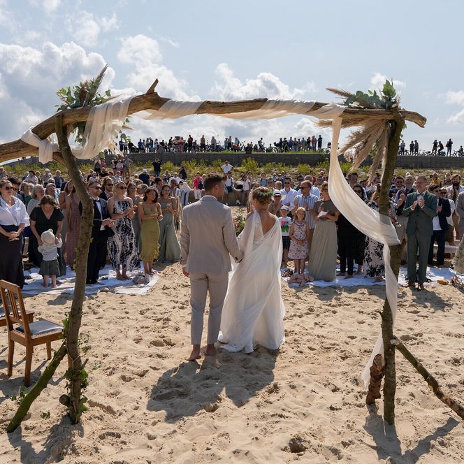 Brautpaar und Gäste am Strand