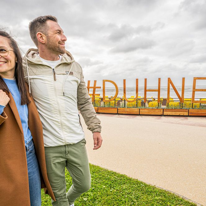 Ein Pärchen spaziert über die Strandpromenade in Duhnen