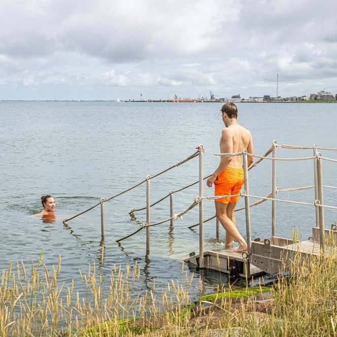 Ein junges Paar schwimmt in der Grimmershörnbucht