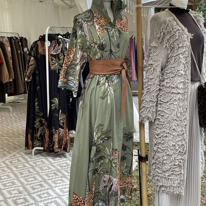 Ein Kleid und ein Mantel an einem Stand mit selbstgenähter Kleidung