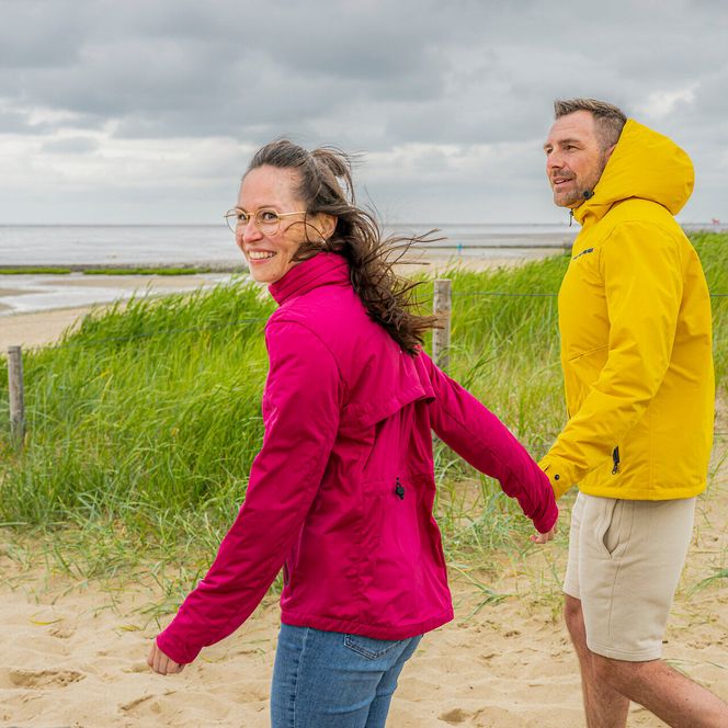 Ein Paar in wetterfesten Jacken am Strand