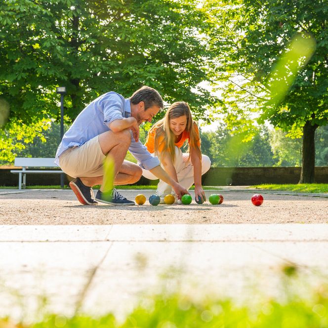 Ein Paar spielt auf der Boule-Bahn im Kurpark