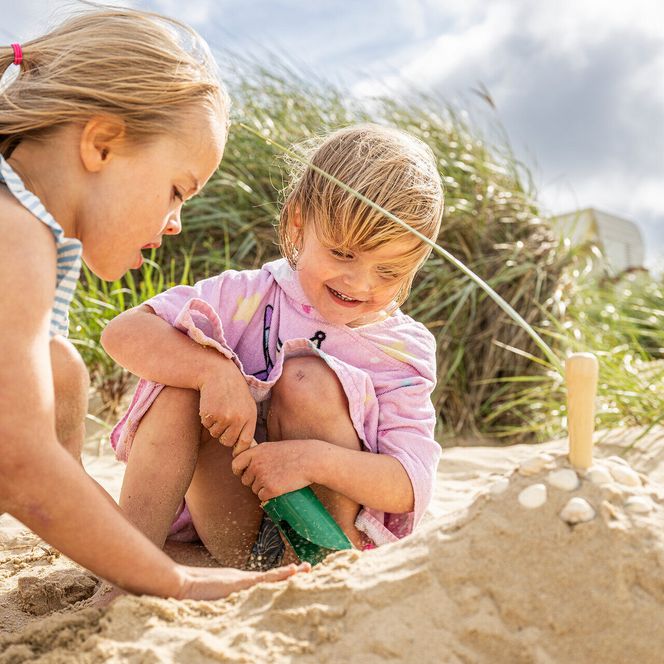 Kinder spielen am Strand von Döse