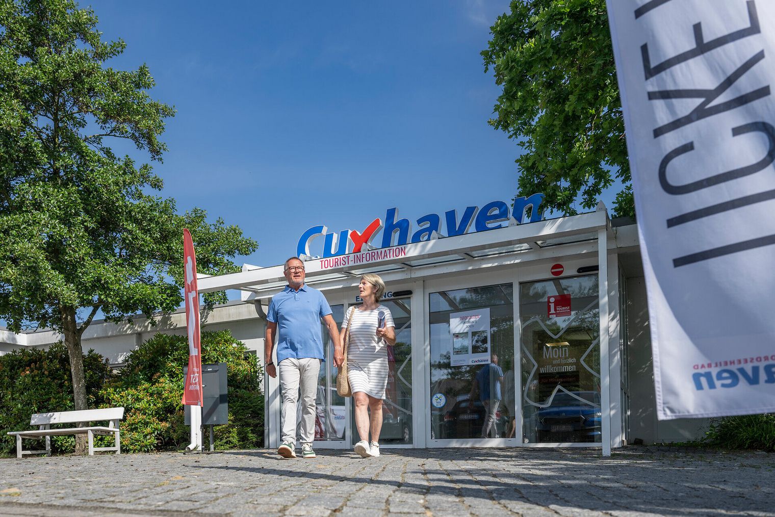 Urlaubspaar verlässt das Haus der Kurverwaltung in Duhnen
