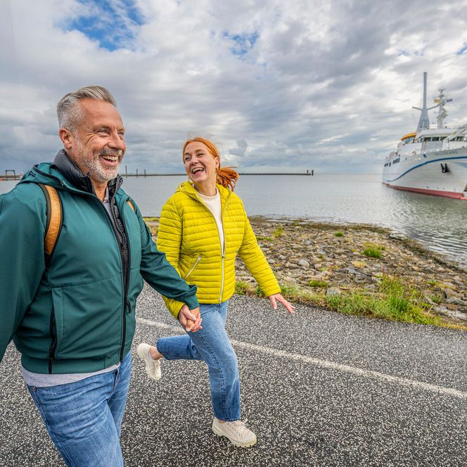 Ein Paar spaziert am Grünstrand in der Grimmershörnbucht