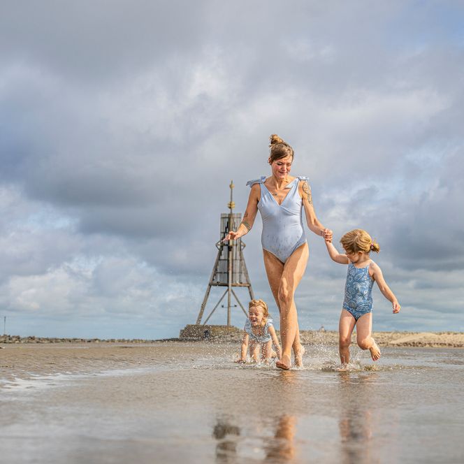 Eine Mutter mit ihren Kindern im Watt in Döse