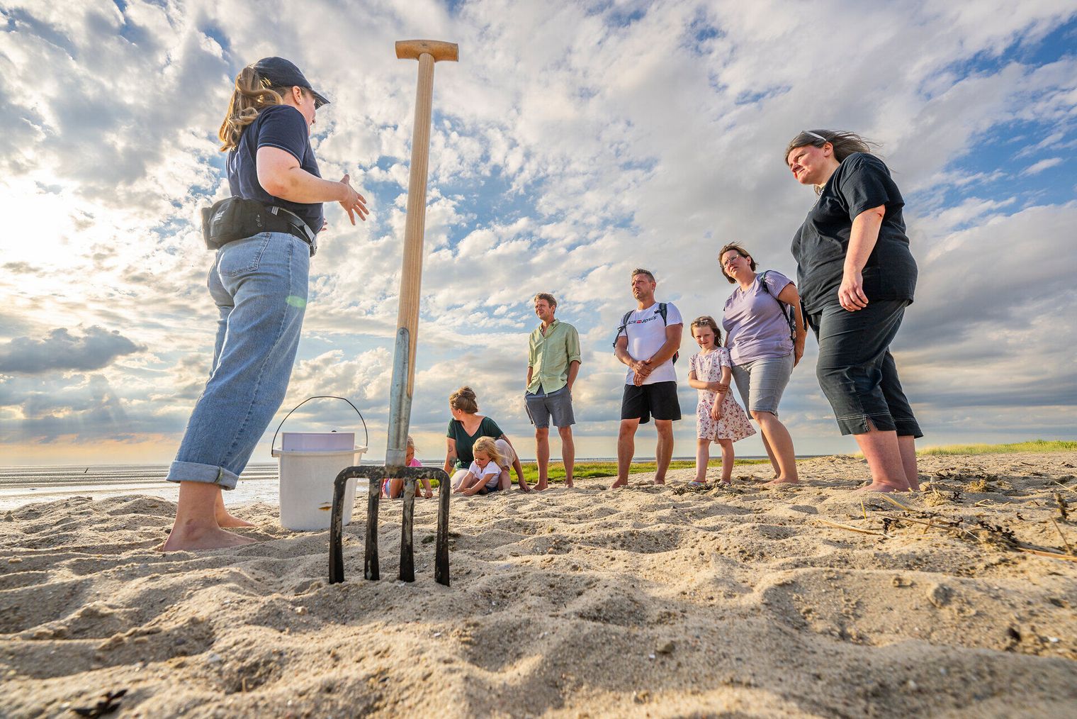 Eine Gruppe Wattwanderer stehen am Strand bevor sie ins Watt laufen