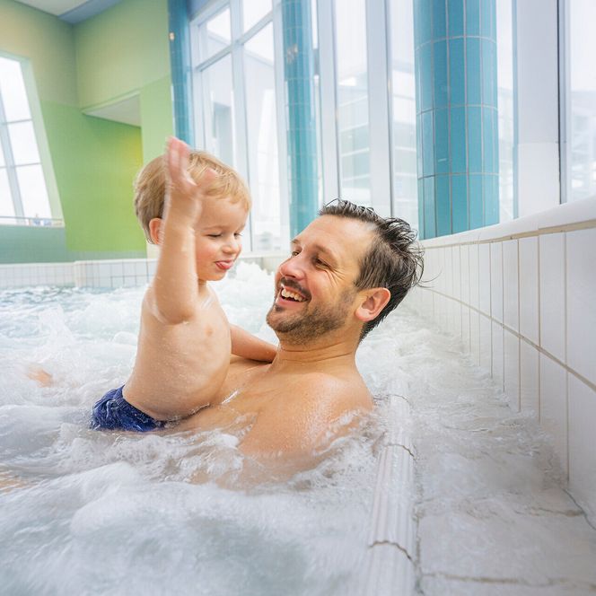 Papa mit Kind auf den Whirlliegen im ahoi!