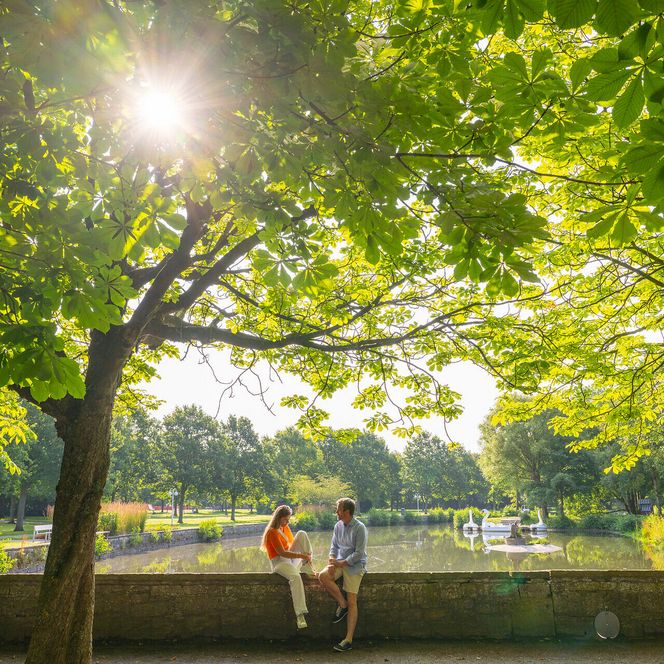 Ein Paar auf der Mauer am See im Kurpark