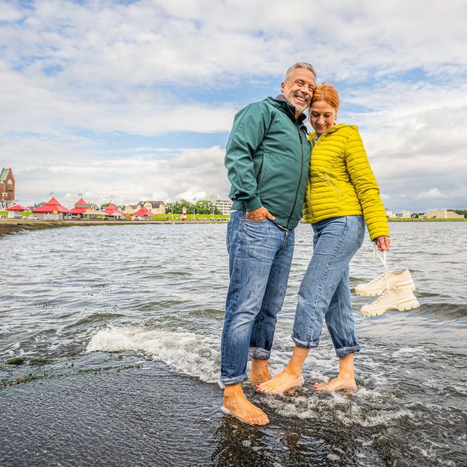 Ein Paar Barfuß in der Bucht an der Wasserkante